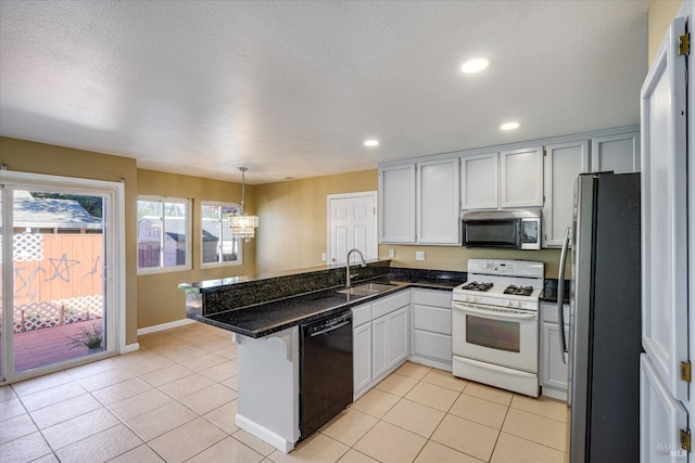 kitchen featuring a peninsula, white cabinets, stainless steel appliances, and hanging light fixtures