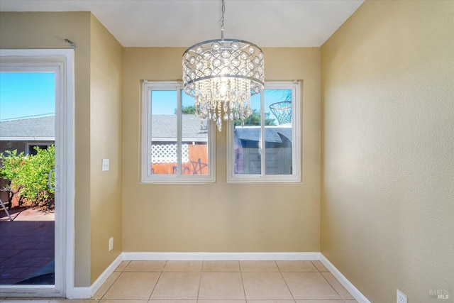 unfurnished dining area featuring light tile patterned floors, baseboards, and an inviting chandelier