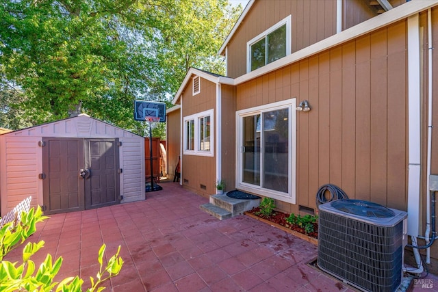 view of patio / terrace featuring a storage shed, central AC, an outdoor structure, and fence