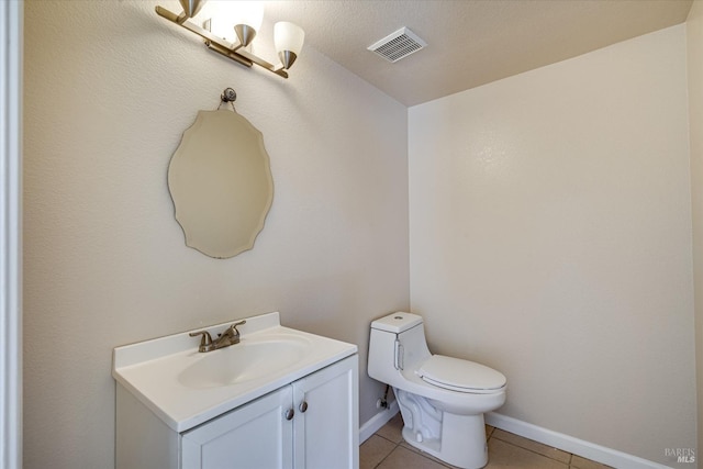 half bath with baseboards, visible vents, toilet, tile patterned floors, and vanity