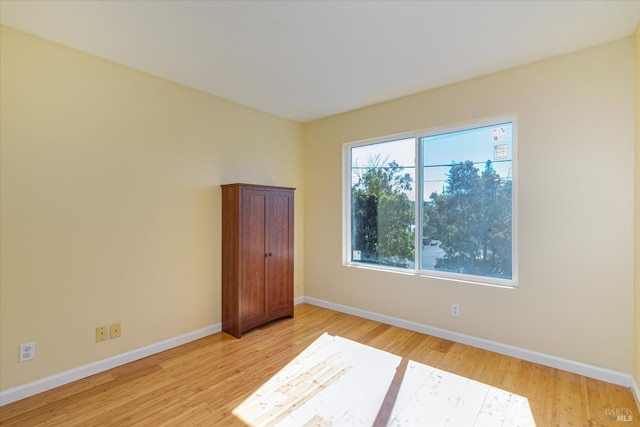 spare room with light wood-style flooring and baseboards