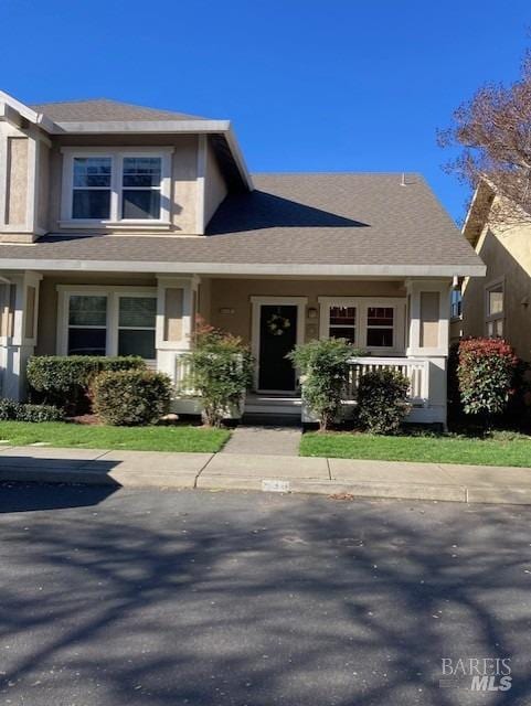 view of front of house featuring a shingled roof and stucco siding