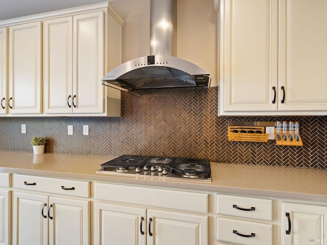 kitchen featuring light countertops, stainless steel gas stovetop, decorative backsplash, and extractor fan