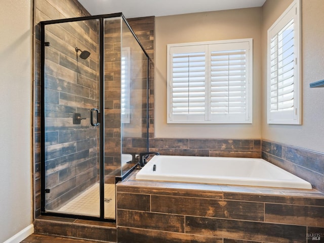 bathroom featuring a stall shower and a bath