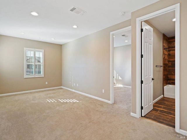 carpeted empty room featuring recessed lighting, visible vents, and baseboards