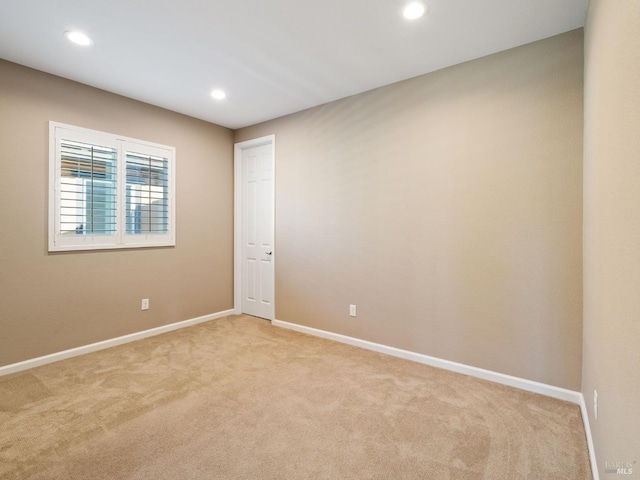 empty room with baseboards, recessed lighting, and light colored carpet