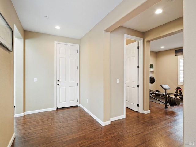 hall featuring dark wood-style floors, baseboards, and recessed lighting