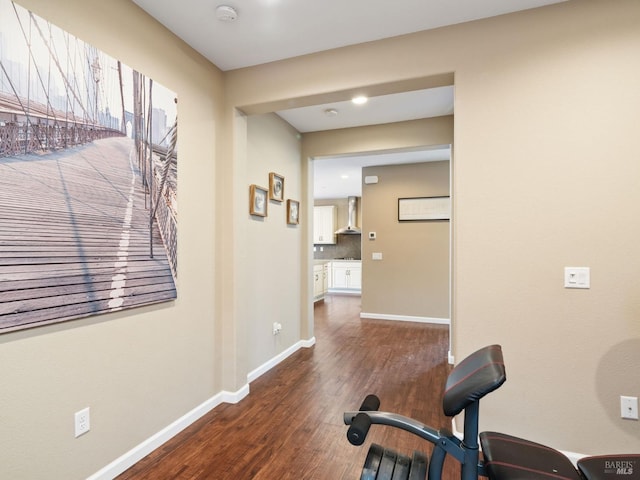 exercise area with dark wood-style flooring and baseboards