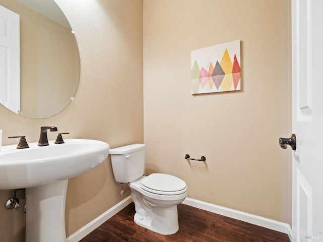 bathroom featuring wood finished floors, toilet, and baseboards