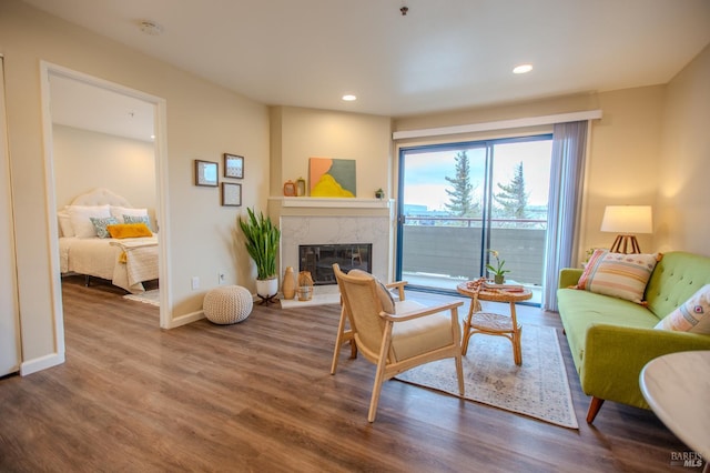 living room featuring recessed lighting, a fireplace, wood finished floors, and baseboards