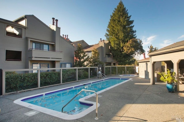 community pool with a community hot tub, a patio area, and fence