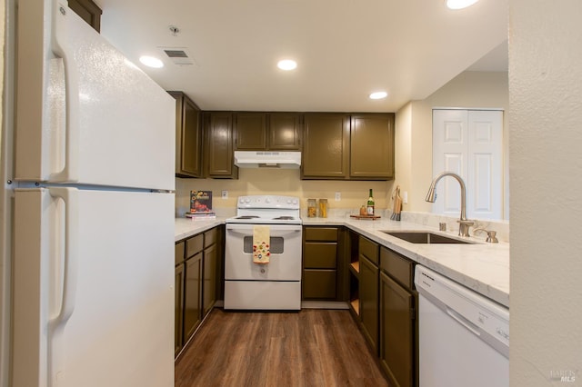 kitchen featuring white appliances, visible vents, dark wood finished floors, under cabinet range hood, and a sink