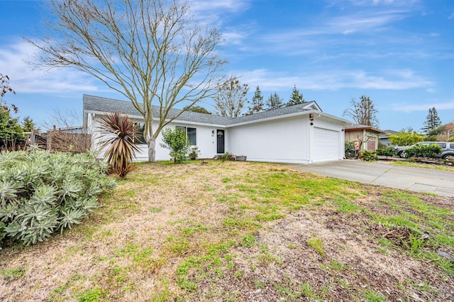 single story home with a garage, a front yard, concrete driveway, and stucco siding