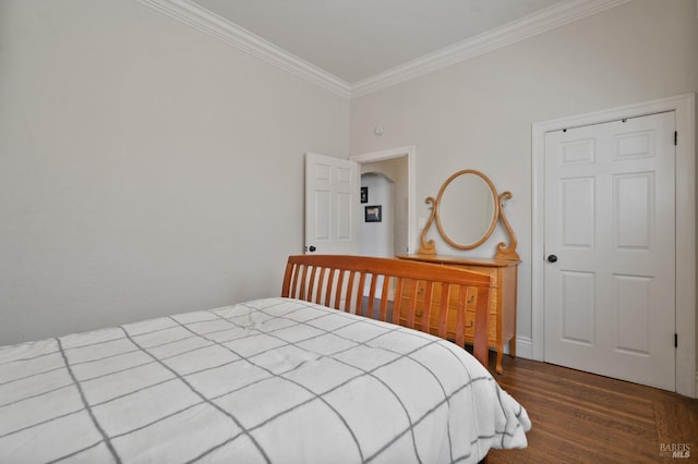 bedroom featuring ornamental molding and wood finished floors