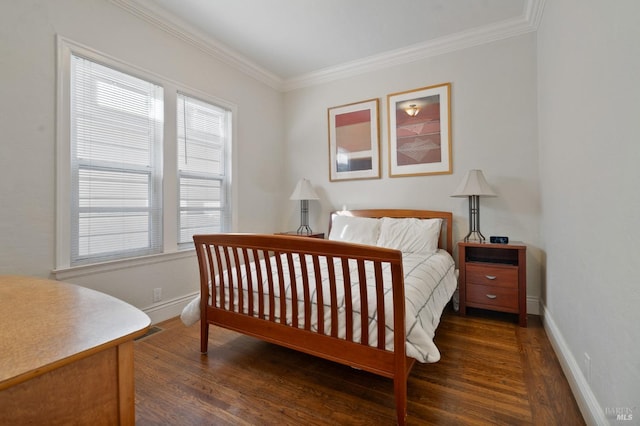 bedroom with ornamental molding, visible vents, baseboards, and wood finished floors