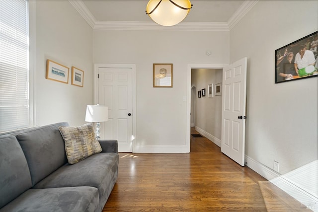 living area featuring baseboards, ornamental molding, and wood finished floors