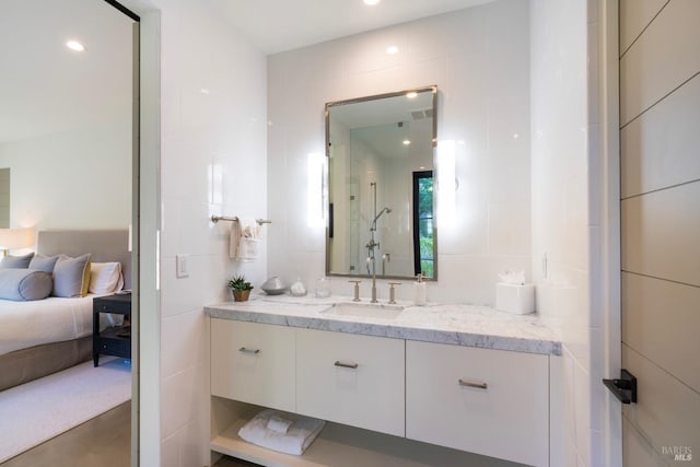full bathroom with tasteful backsplash, vanity, and tile walls