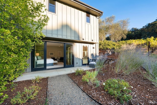 back of property featuring board and batten siding and a patio area