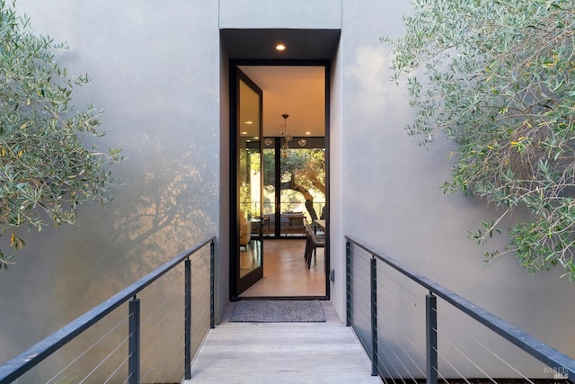 view of exterior entry featuring stucco siding and a balcony