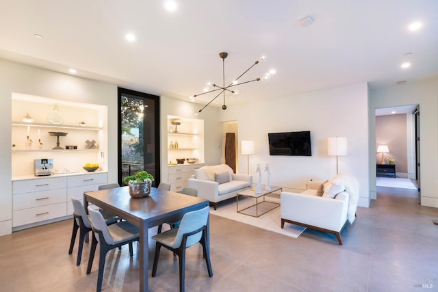 dining room with a notable chandelier, built in shelves, and recessed lighting