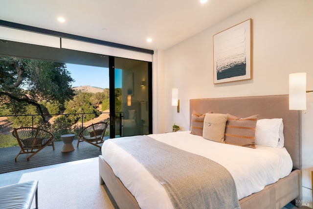 bedroom featuring access to outside, expansive windows, and recessed lighting
