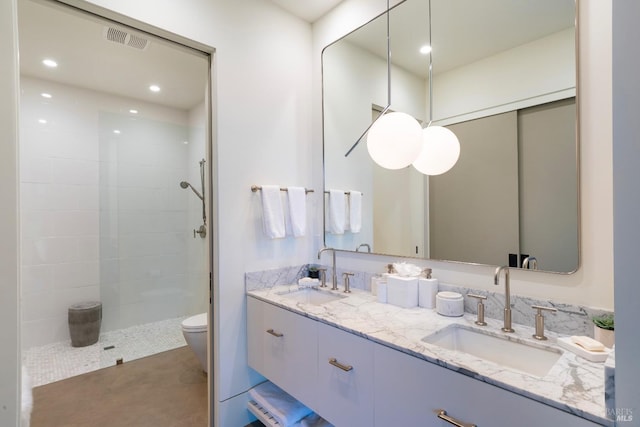bathroom featuring a sink, visible vents, and a tile shower