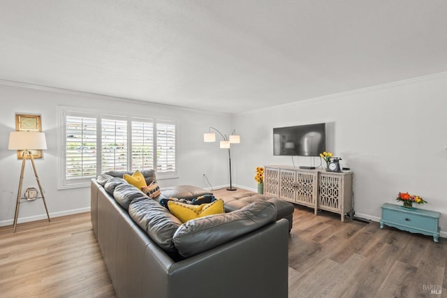 living area featuring crown molding, baseboards, and wood finished floors