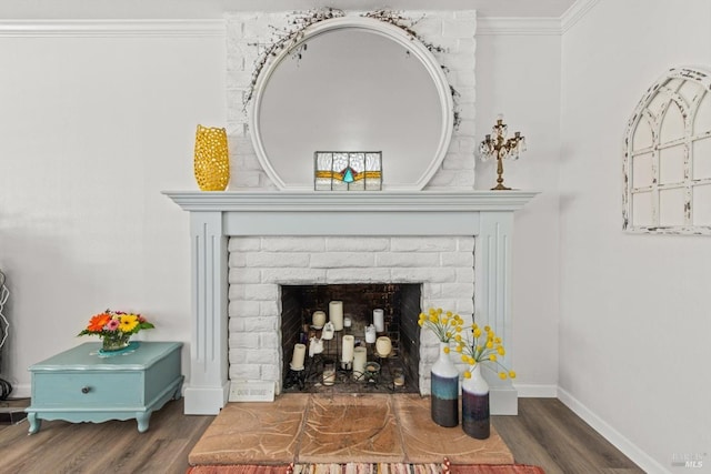 room details featuring a brick fireplace, baseboards, ornamental molding, and wood finished floors