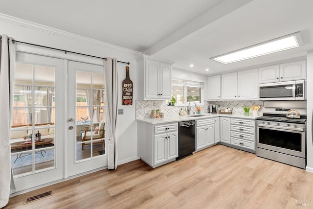 kitchen with a sink, visible vents, white cabinets, french doors, and appliances with stainless steel finishes