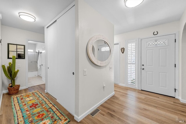 foyer featuring visible vents, light wood-style flooring, and baseboards