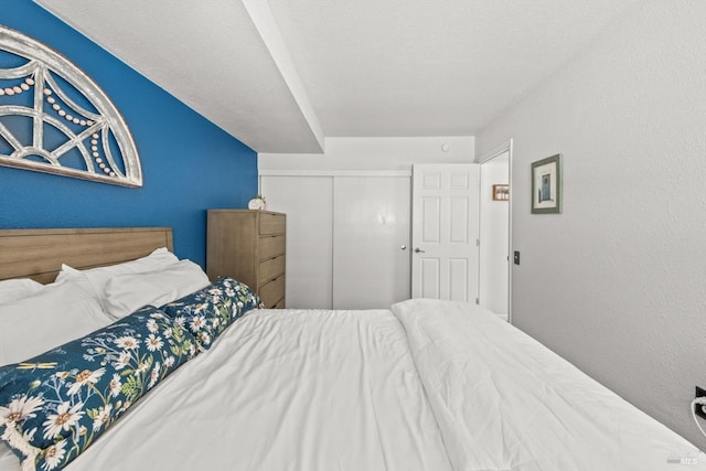 bedroom with a closet and a textured wall