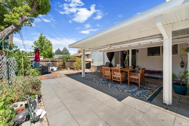 view of patio featuring outdoor dining space and fence