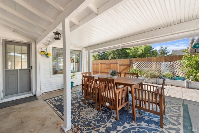 view of patio with outdoor dining area and fence