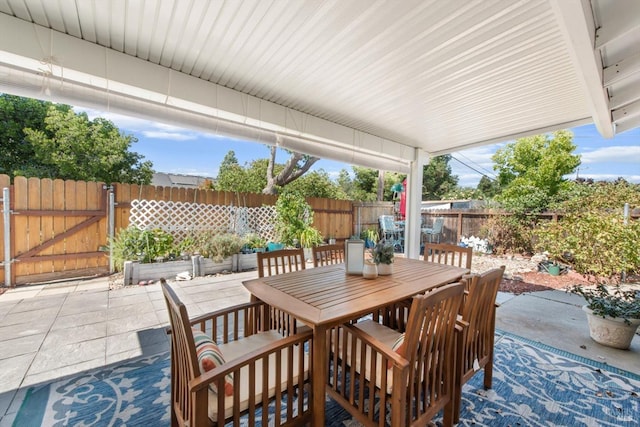 view of patio featuring a fenced backyard, a gate, and outdoor dining area