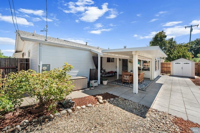 rear view of house with a patio area, an outdoor structure, a fenced backyard, and a storage shed