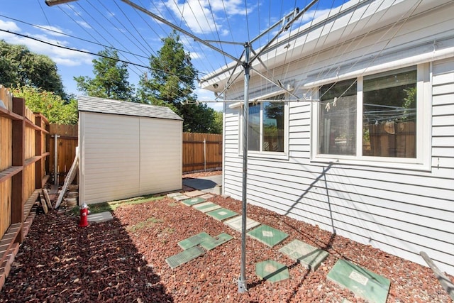 view of property exterior with a storage unit, an outdoor structure, and a fenced backyard