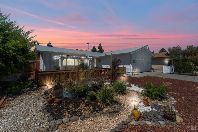 ranch-style house with concrete driveway, an attached garage, and a pergola