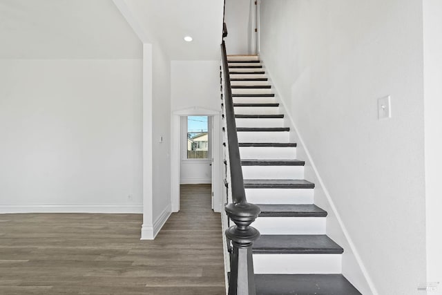 staircase with baseboards, wood finished floors, and recessed lighting