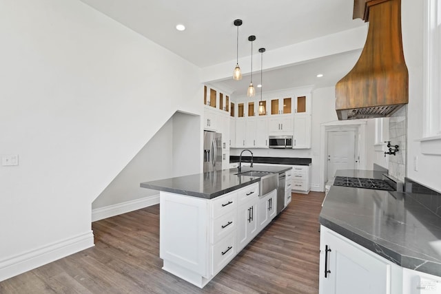 kitchen with dark countertops, premium range hood, stainless steel appliances, and dark wood-type flooring