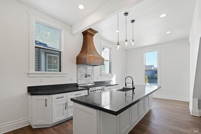 kitchen featuring dark wood finished floors, dark countertops, stove, white cabinetry, and a sink