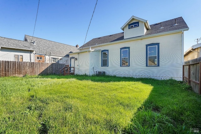 back of house featuring a yard, cooling unit, and fence