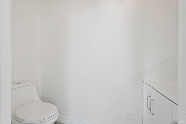 bathroom featuring baseboards and toilet