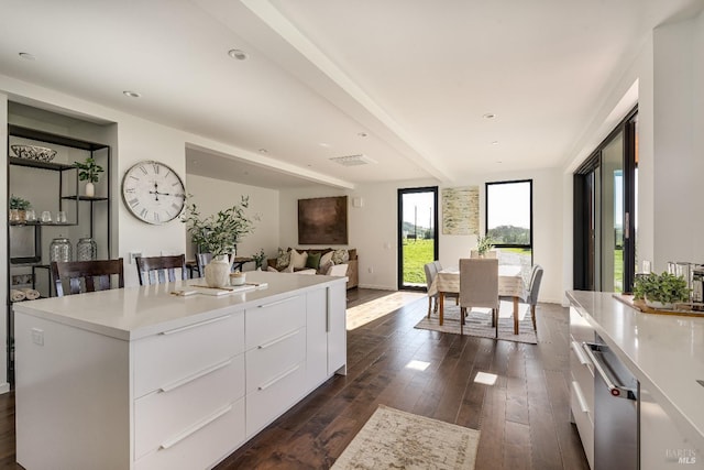 kitchen featuring light countertops, dark wood-type flooring, white cabinetry, a kitchen island, and modern cabinets