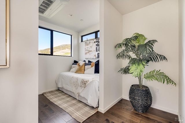 bedroom featuring baseboards, visible vents, and dark wood finished floors