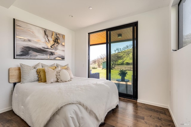 bedroom featuring dark wood-style floors, access to outside, and baseboards