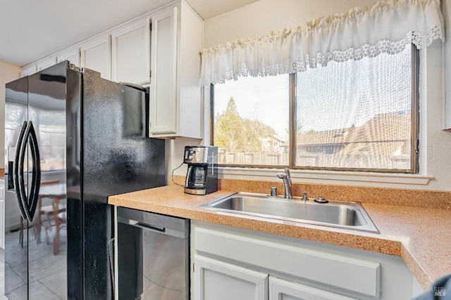 kitchen with stainless steel dishwasher, a sink, black fridge with ice dispenser, and a healthy amount of sunlight