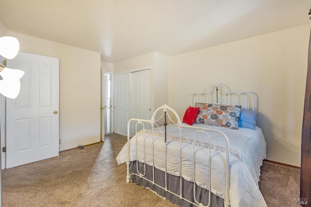 carpeted bedroom featuring baseboards and a closet