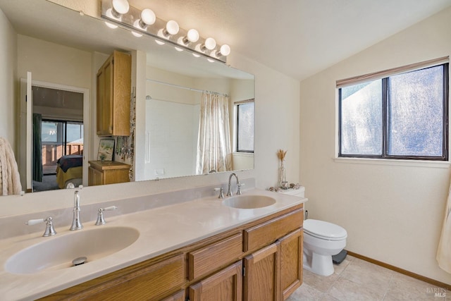 bathroom featuring lofted ceiling, a sink, ensuite bath, and toilet