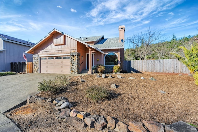 view of front of house with a garage, stone siding, fence, and concrete driveway