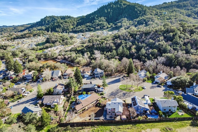 drone / aerial view featuring a residential view, a mountain view, and a forest view